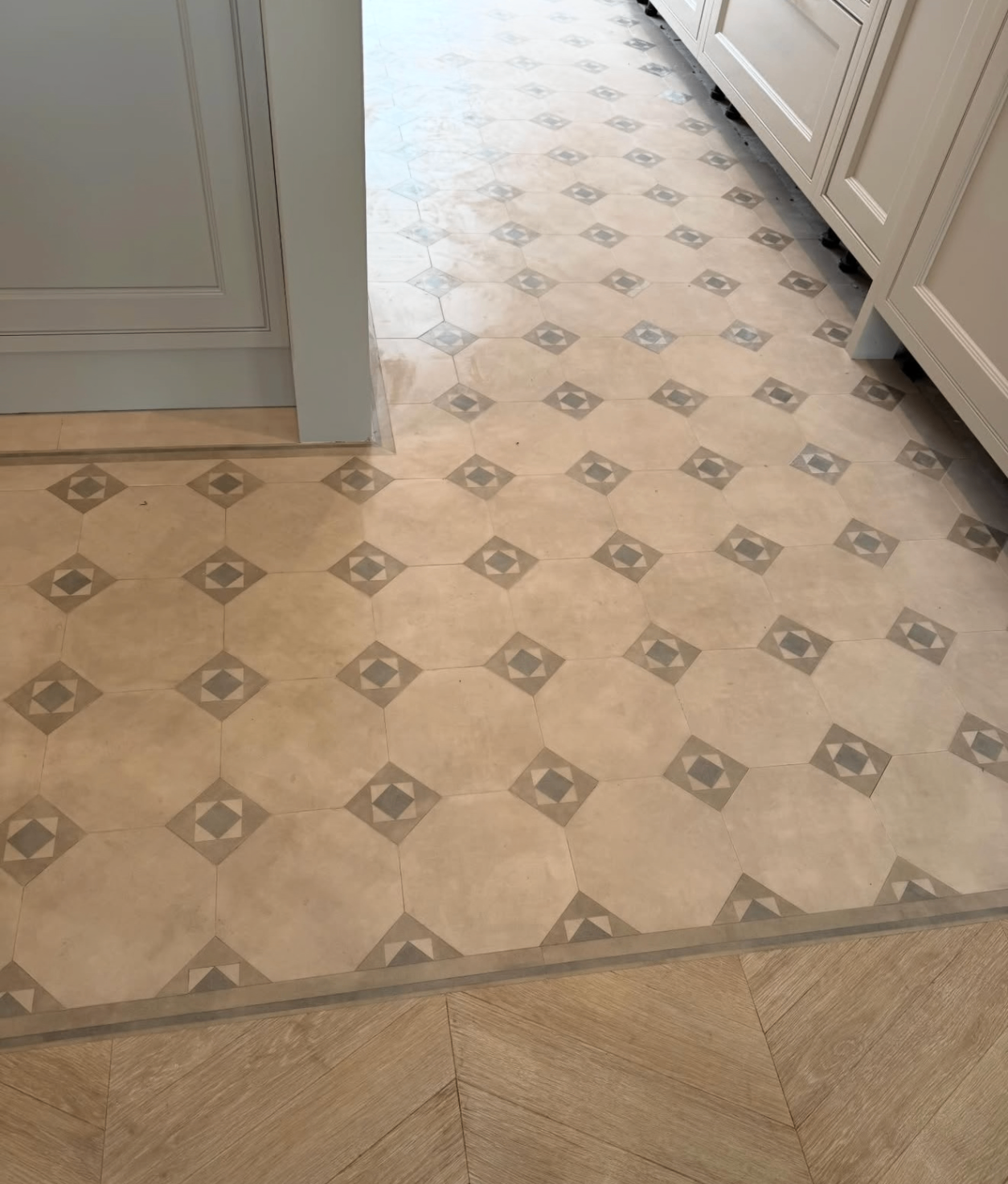 Patterned stone-effect floor with geometric insets installed in a kitchen