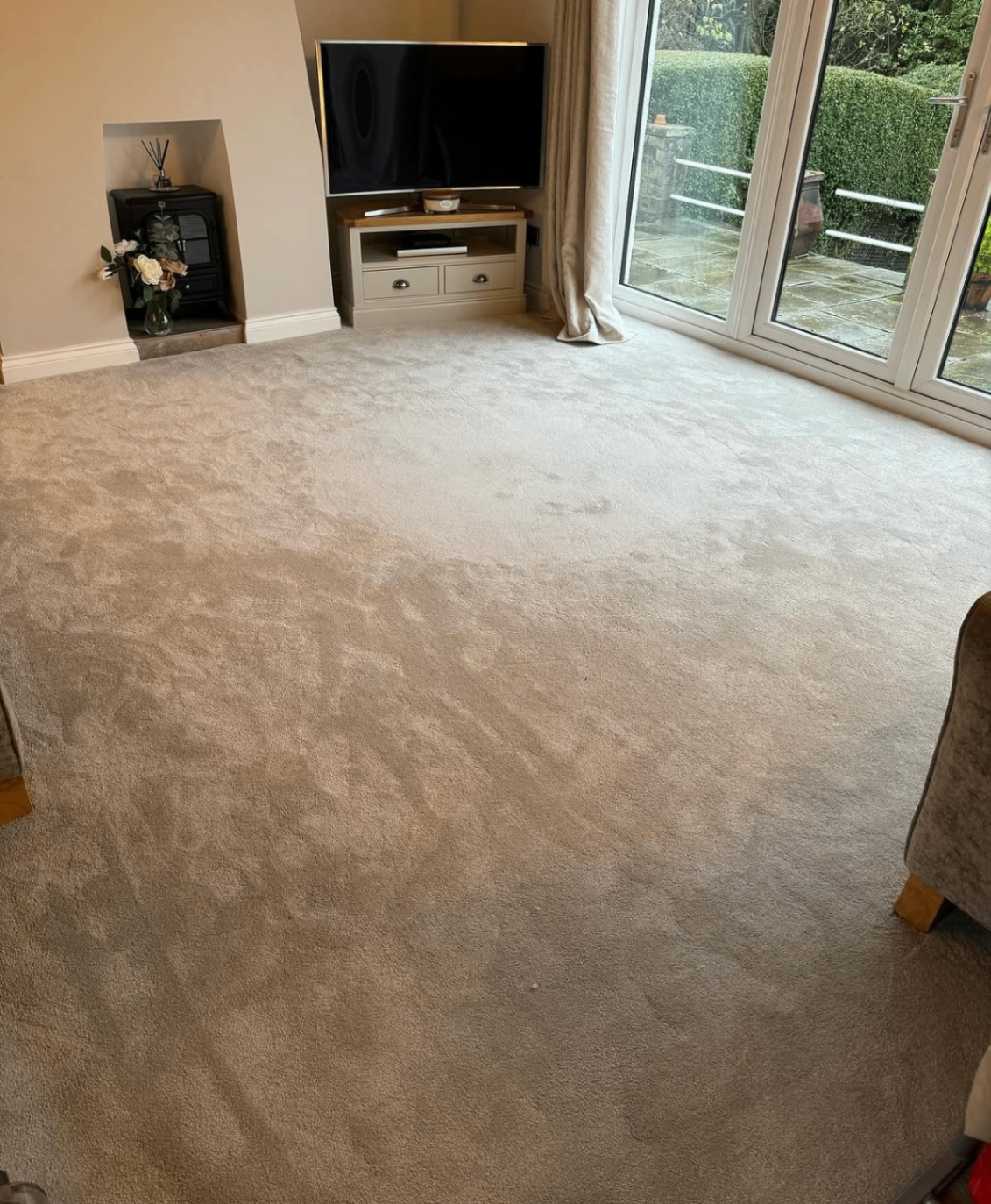 Neutral carpet fitted in a bright living room with patio doors